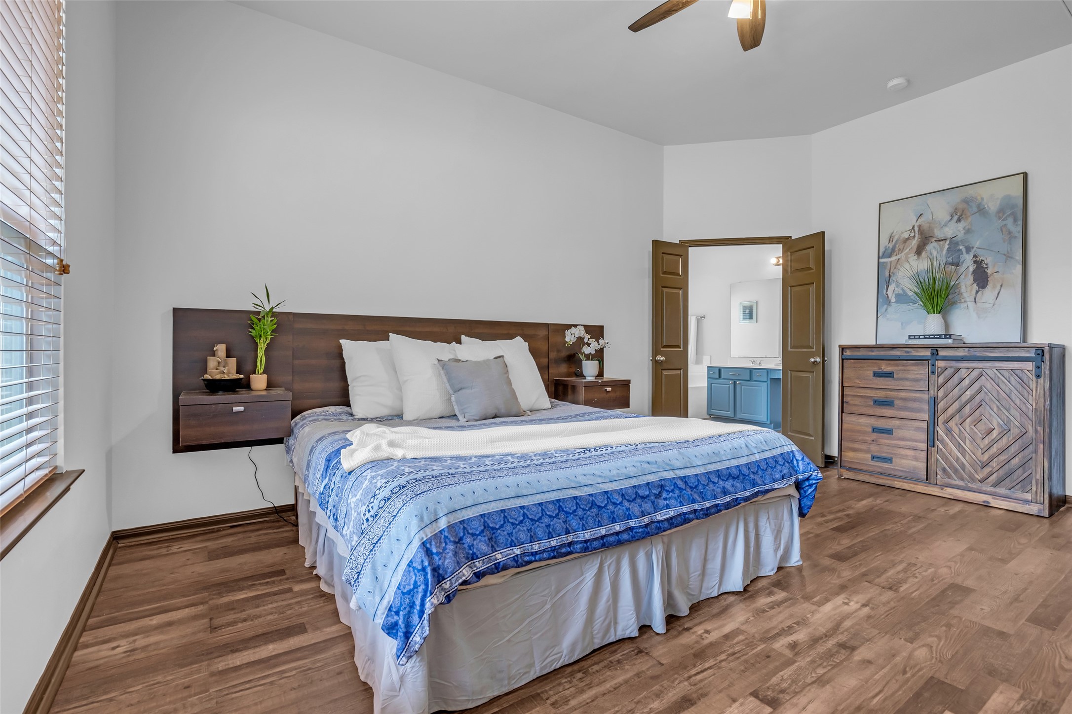 134 South Star Ridge Circle The Woodlands, TX 77382 - Photo 15 of 29 a bedroom with a bed a dresser with wooden floor