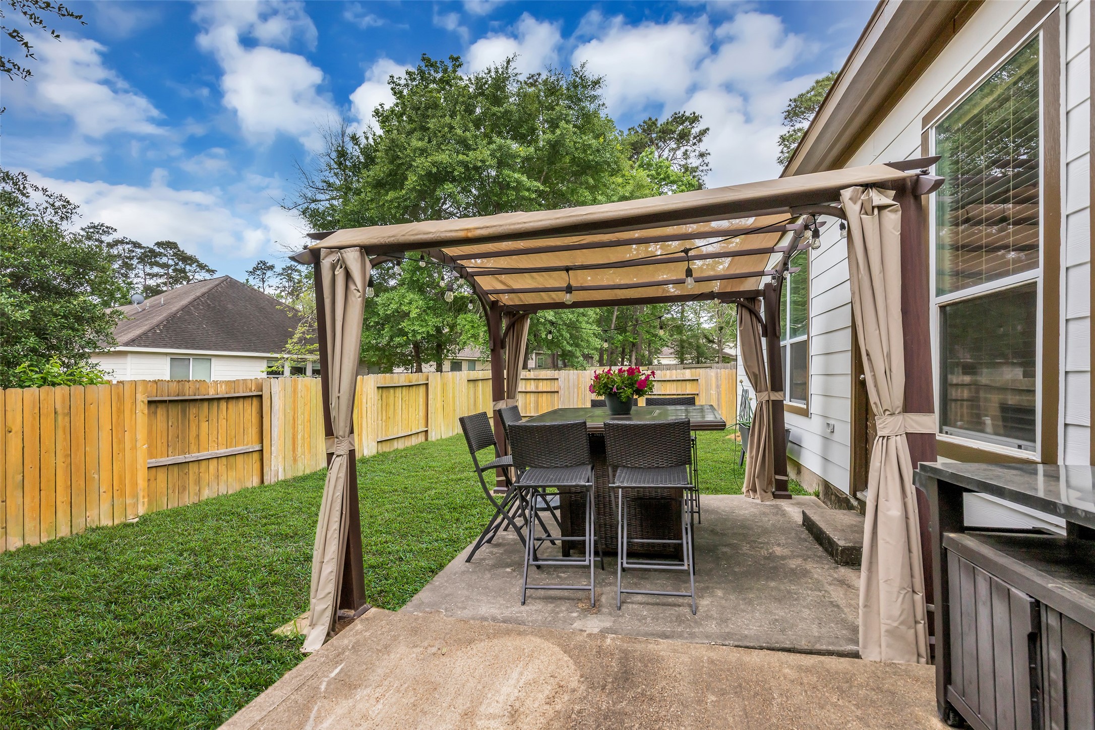 134 South Star Ridge Circle The Woodlands, TX 77382 - Photo 28 of 29 a view of a patio with table and chairs potted plants with floor to ceiling window