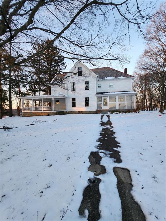 a front view of a house with a yard covered in snow