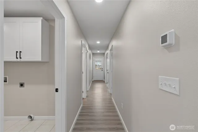 a view of a hallway with wooden floor and closet