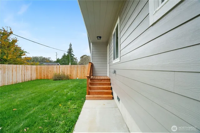 a view of a pathway of a house with wooden fence
