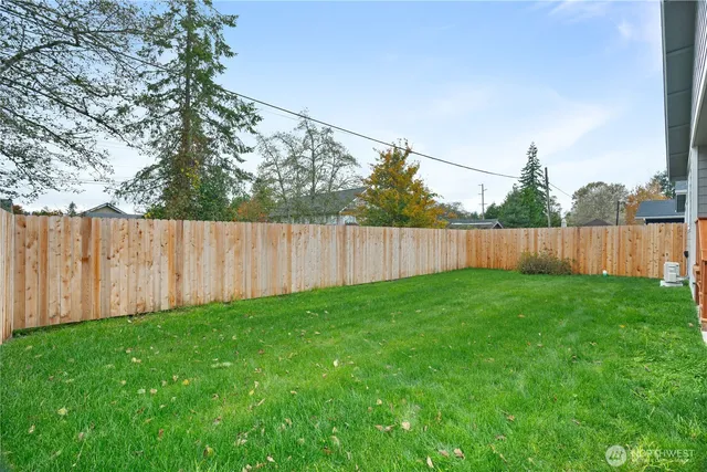 a view of a backyard with wooden fence