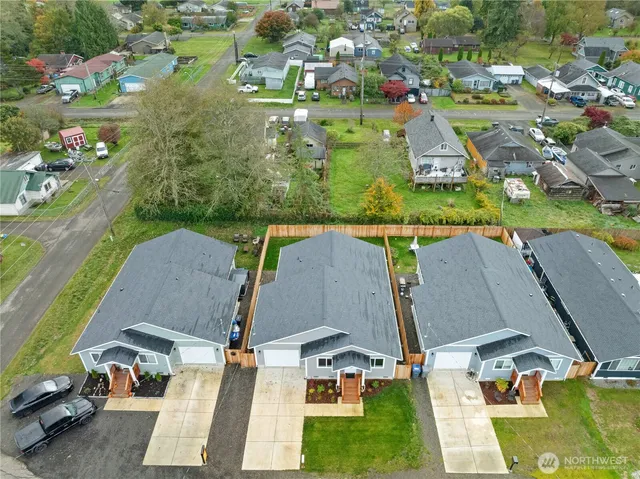 an aerial view of residential houses with outdoor space and parking