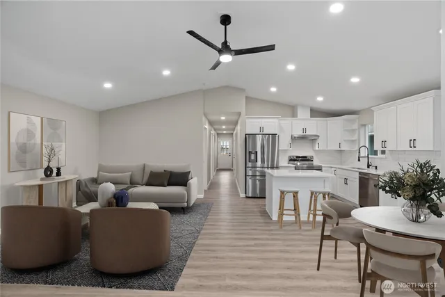 a living room with stainless steel appliances furniture and a view of kitchen