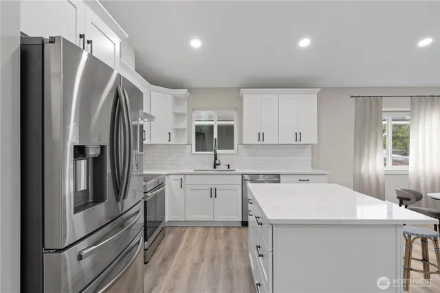 a kitchen with a refrigerator a sink and cabinets