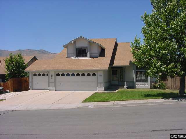 a view of a house with a yard and large tree
