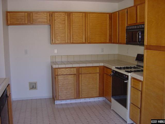 5301 Simons Drive Reno, NV 89523 - Photo 3 of 8 a kitchen with stainless steel appliances granite countertop a stove and a microwave