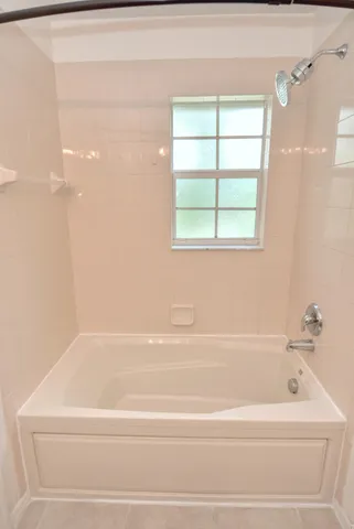 a bathroom with a bathtub and next to a window