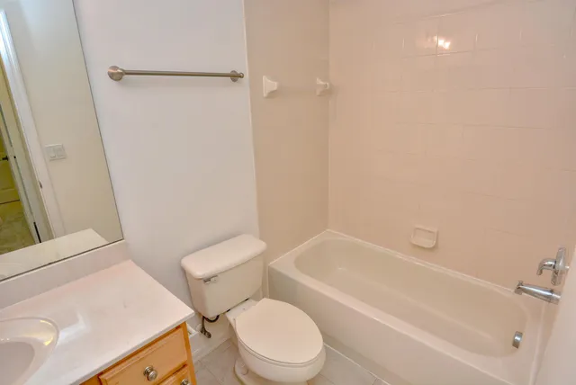 a white toilet sitting next to a bath tub