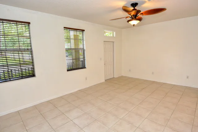 a view of a room with a ceiling fan and window