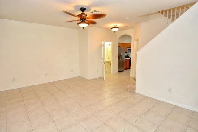a view of a big room with chandelier fan and windows