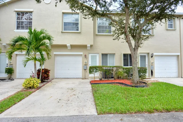 front view of a house with a yard and an trees