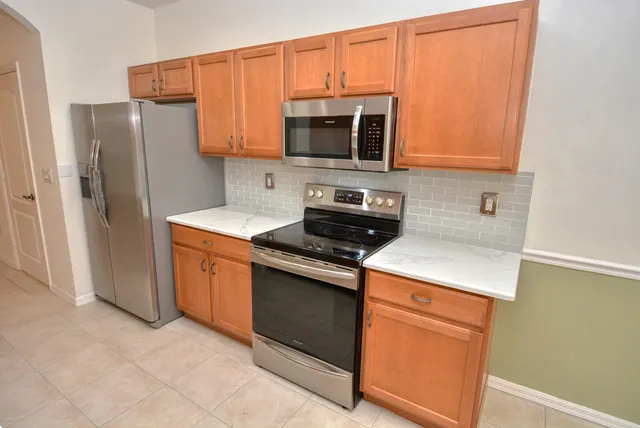 a kitchen with stainless steel appliances a stove microwave and refrigerator