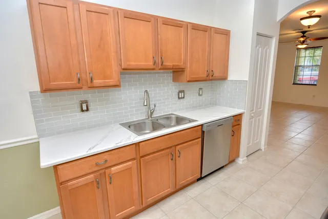 a kitchen with stainless steel appliances granite countertop a sink dishwasher and cabinets with wooden floor