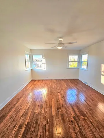 a large bedroom with wooden floor bed and window