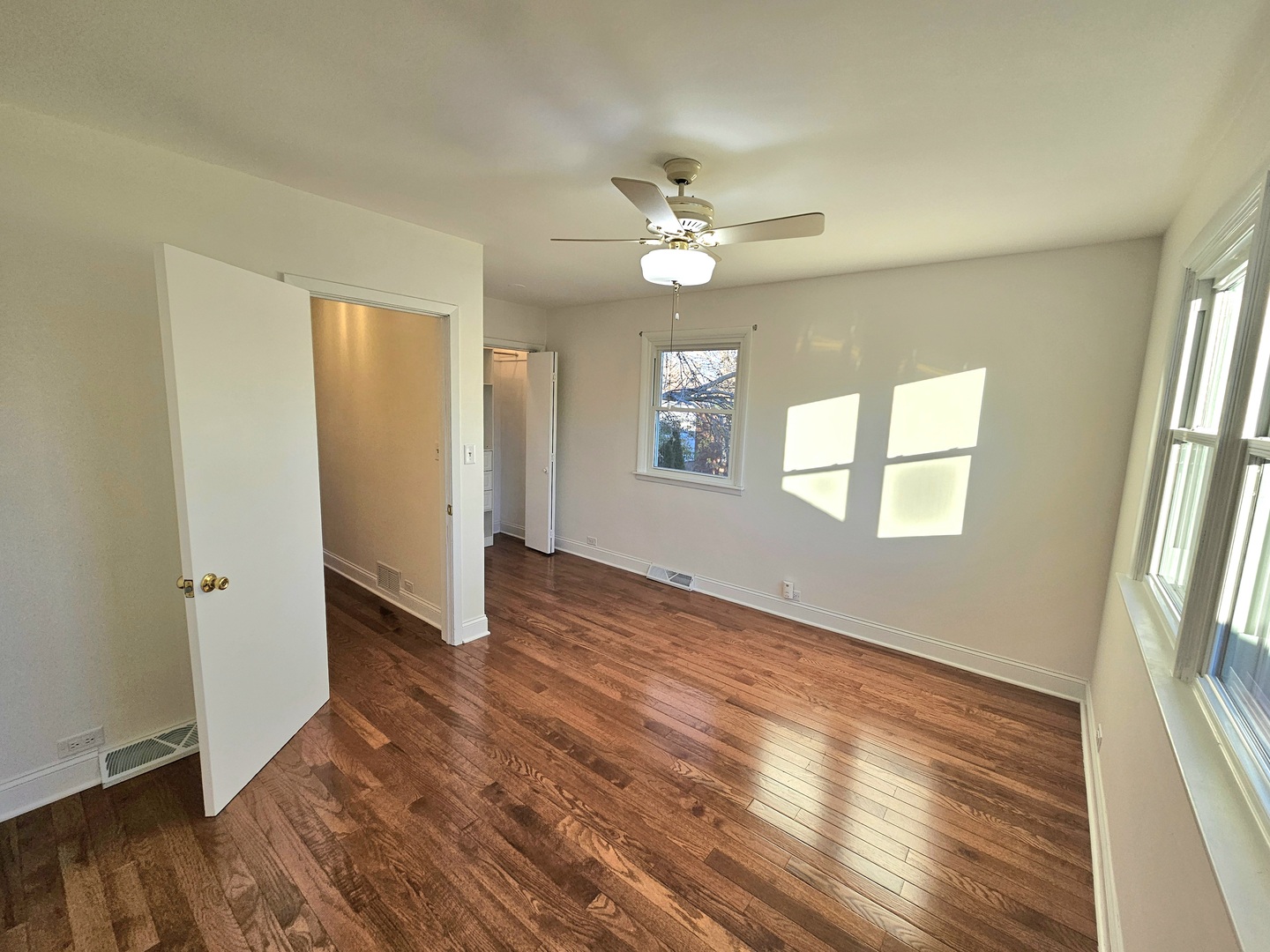 7434 Emerson Street Morton Grove, IL 60053 - Photo 16 of 43 an empty room with wooden floor fan and windows