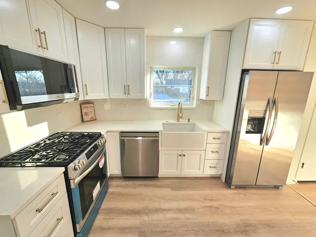 a kitchen with stainless steel appliances a refrigerator sink and cabinets