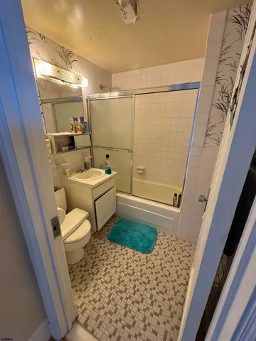 a bathroom with a sink a toilet a shower and vanity