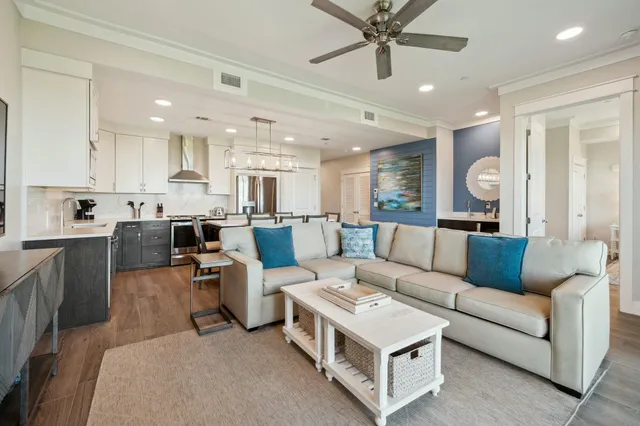 a living room with furniture kitchen view and a chandelier