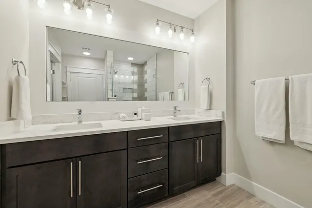 a bathroom with double sink and a mirror