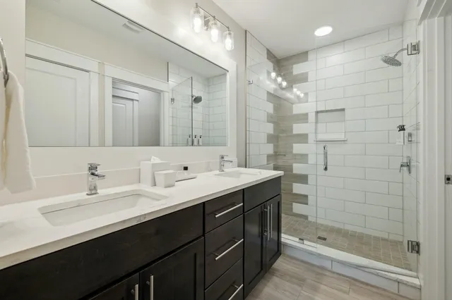 a bathroom with a double vanity sink mirror and shower