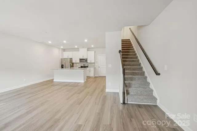 a view of a kitchen with wooden floor and stairs