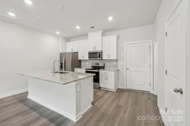 a kitchen with appliances a sink and cabinets