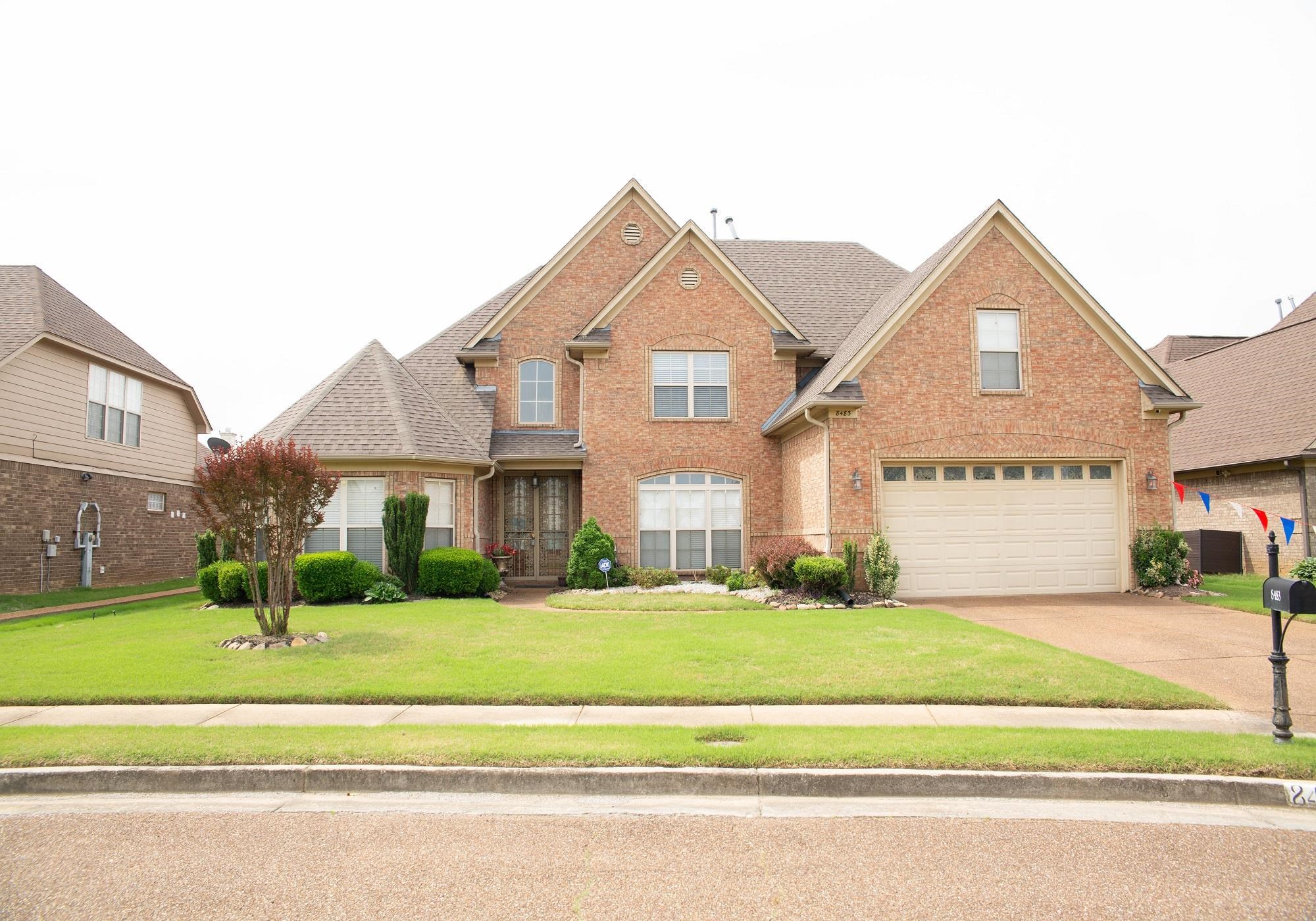 8483 Boothes Ridge Drive Memphis, TN 38125 - Photo 1 of 38 Traditional home with an attached garage, concrete driveway, a front lawn, and brick siding