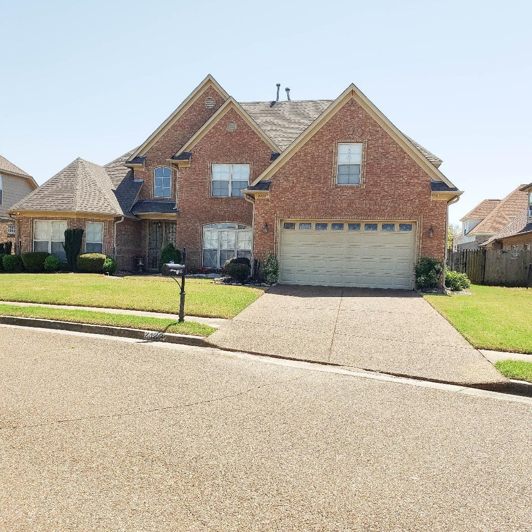 8483 Boothes Ridge Drive Memphis, TN 38125 - Photo 5 of 38 Traditional-style house with a front lawn, brick siding, driveway, and a garage