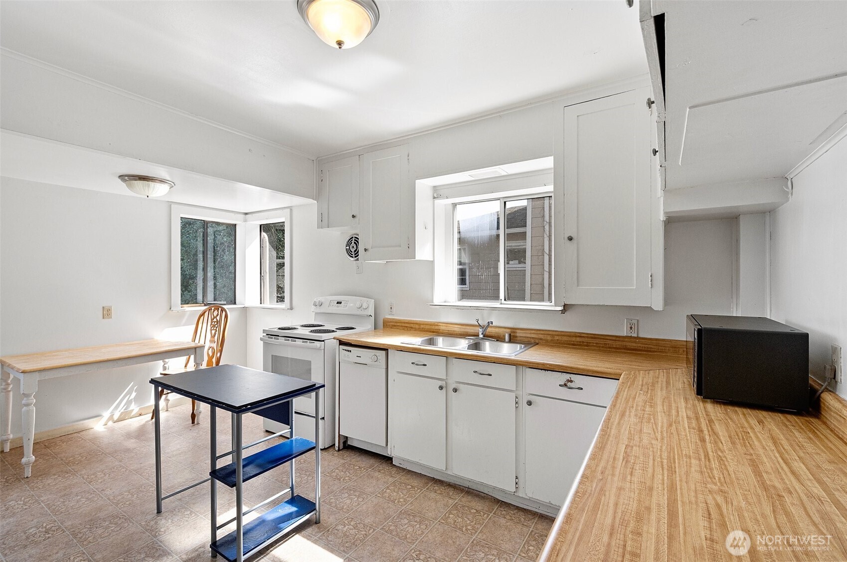 5016 7th Avenue Northeast Seattle, WA 98105 - Photo 18 of 36 a view of a kitchen with kitchen island granite countertop wooden floors and a sink