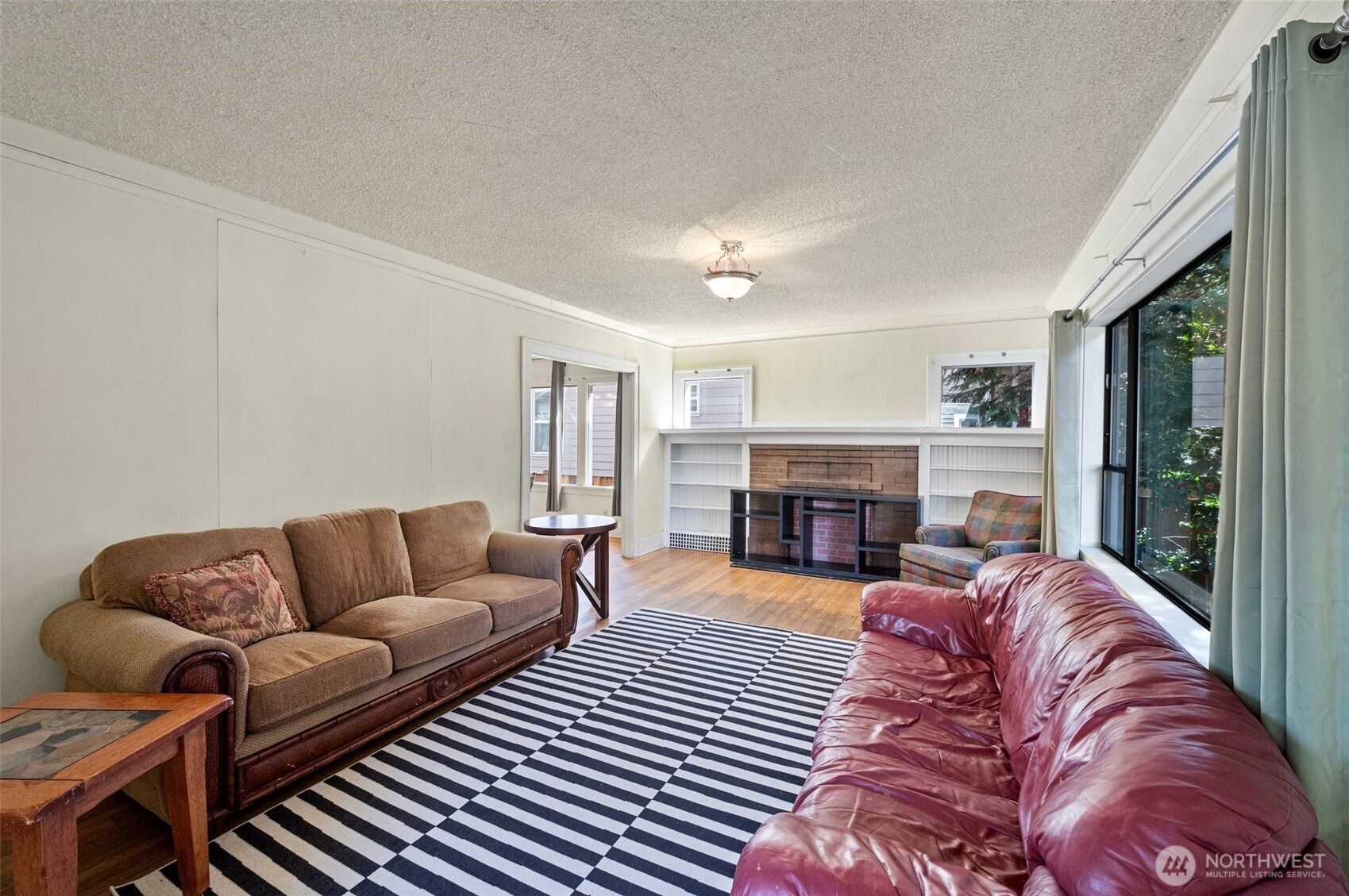5016 7th Avenue Northeast Seattle, WA 98105 - Photo 7 of 36 a living room with furniture a fireplace and a large window