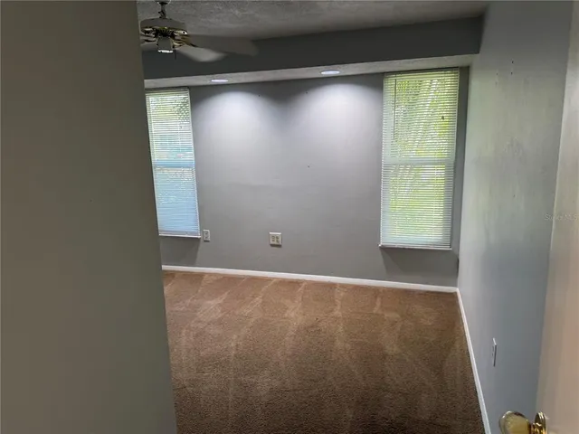 an empty room with a window and a fan