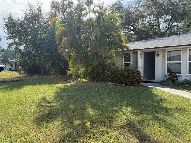 a view of a house with backyard and sitting area