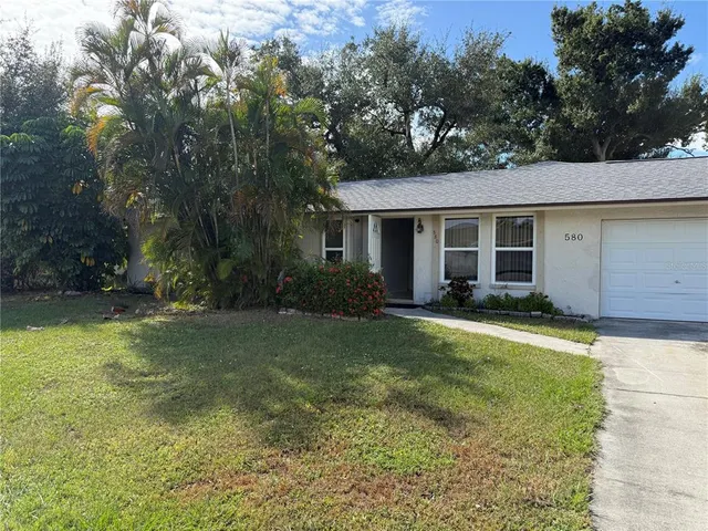 a view of a house with backyard and trees