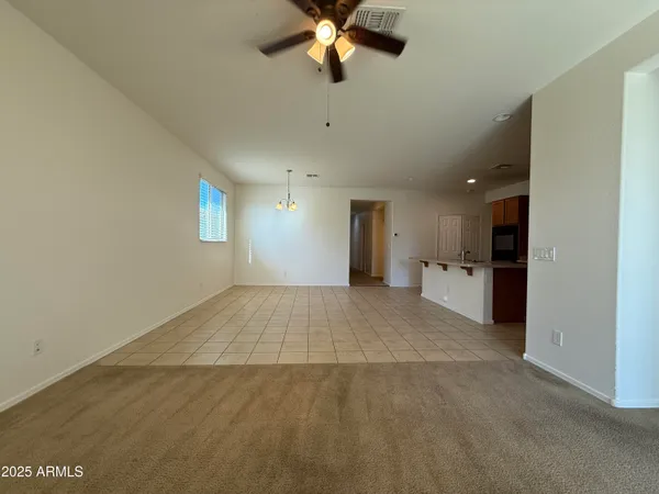 a view of a livingroom with a ceiling fan window and a kitchen view