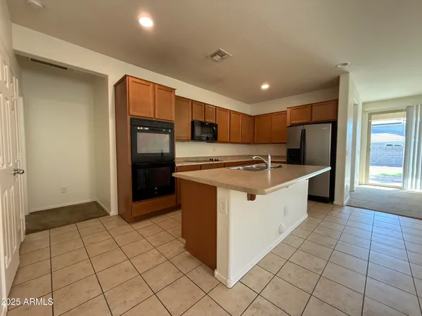 a kitchen with stainless steel appliances granite countertop a refrigerator and a sink