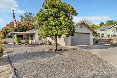 a view of a house with a tree and a yard