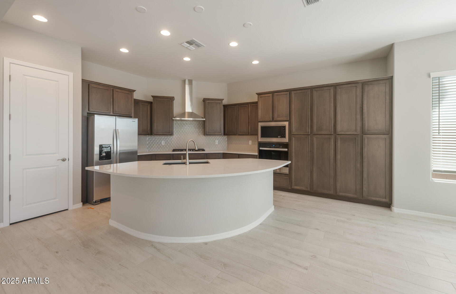 7802 West Mockingbird Way Florence, AZ 85132 - Photo 7 of 34 a large room with kitchen island sink refrigerator and cabinets