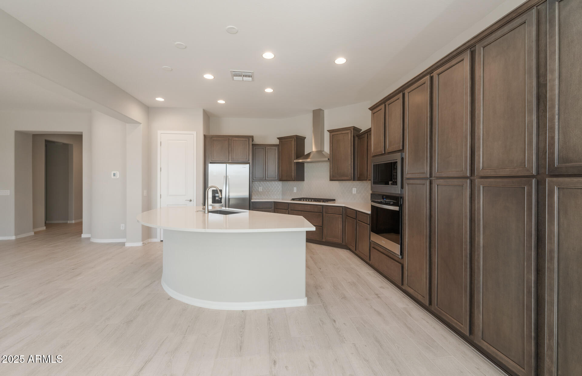 7802 West Mockingbird Way Florence, AZ 85132 - Photo 8 of 34 a large kitchen with a center island wooden floor stainless steel appliances and cabinets