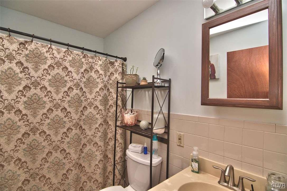 4280 Pne Rdg Drive Bushkill, PA 18324 - Photo 20 of 32 a bathroom with a toilet and a shower curtain