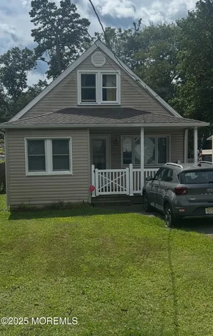 a front view of a house with a garden and trees