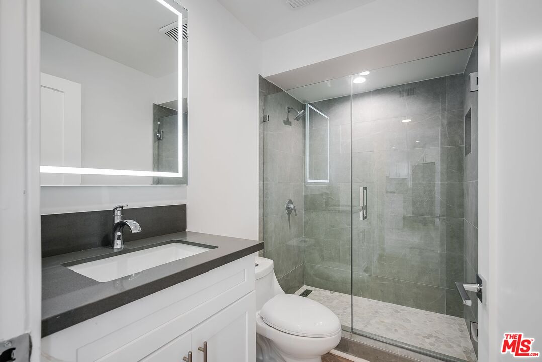 11675 Darlington Avenue, Unit 301 Los Angeles, CA 90049 - Photo 12 of 16 a bathroom with a sink a toilet and shower