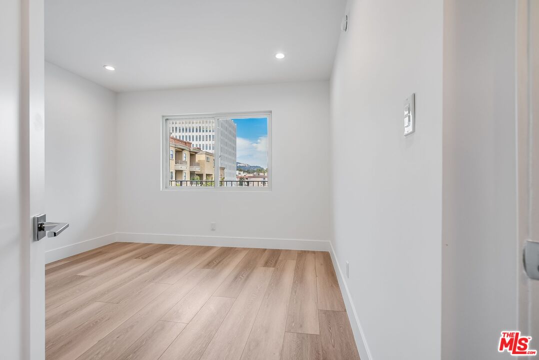 11675 Darlington Avenue, Unit 301 Los Angeles, CA 90049 - Photo 13 of 16 a view of room with window and hardwood floor