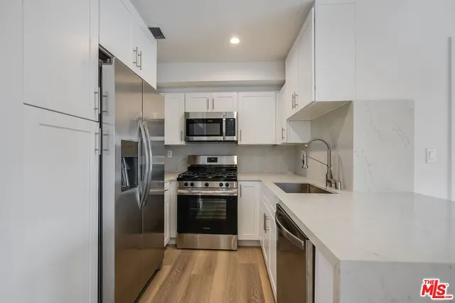 a kitchen with a sink a stove and refrigerator