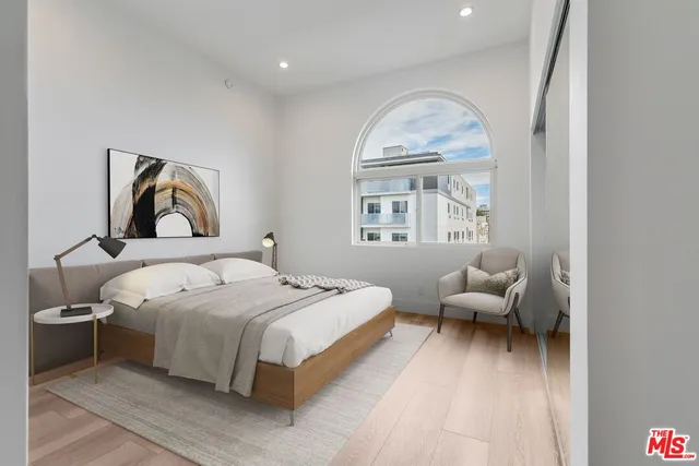 a bedroom with bed and a large window