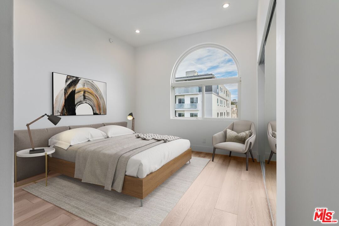 11675 Darlington Avenue, Unit 301 Los Angeles, CA 90049 - Photo 2 of 16 a bedroom with bed and a large window