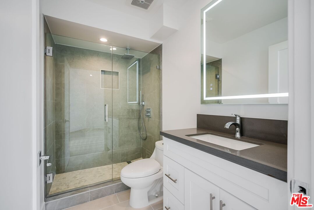 11675 Darlington Avenue, Unit 301 Los Angeles, CA 90049 - Photo 10 of 16 a bathroom with a sink a toilet and shower