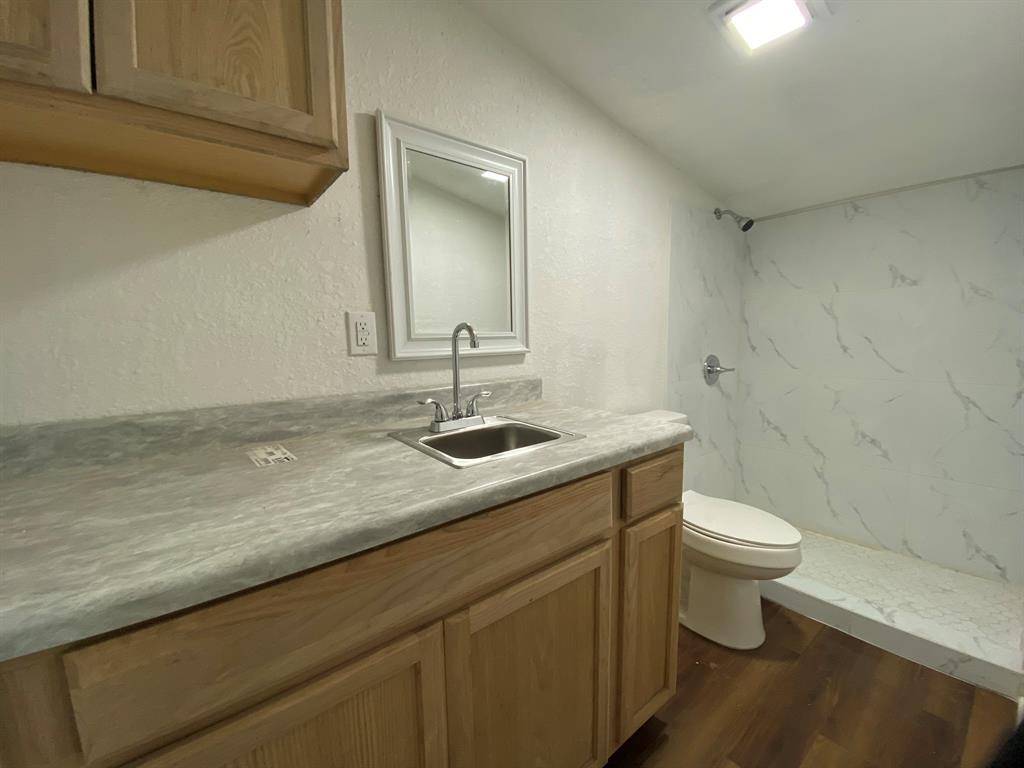 14131 Northwest 3rd Avenue, Unit E Miami, FL 33168 - Photo 1 of 7 a bathroom with a sink a toilet a mirror and vanity