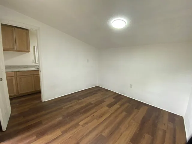 a view of empty room with wooden floor