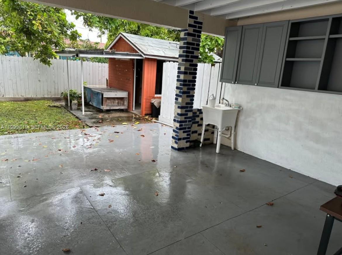 9021 Southwest 30th Terrace Miami, FL 33165 - Photo 11 of 18 a view of a patio with table and chairs a barbeque with wooden fence